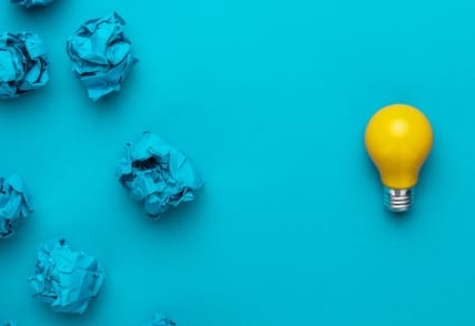 A light bulb and wrapped pieces of paper