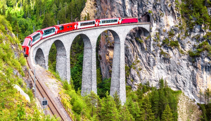 Bernina express on Landwasser Viaduct, Switzerland. It is landmark of Swiss Alps. Nice Alpine landscape in summer. Red glacier train on rail